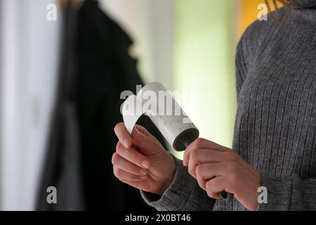Hair remover roller. Woman using reusable clothes lint roller cleaner. Stock Photo