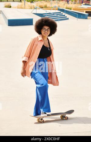 Young African American woman with curly hair riding skateboard in vibrant park, showing skill and freedom. Stock Photo