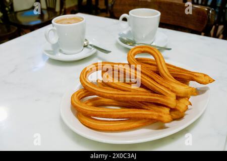 Ration of churros with two cups of coffee. Madrid, Spain. Stock Photo