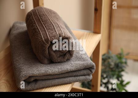 Soft towels on wooden shelf indoors, closeup Stock Photo