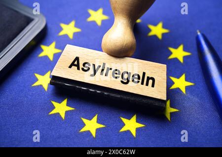 FOTOMONTAGE, Stempel mit Aufschrift Asylregeln auf EU-Fahne, EU-Asylpakt *** FOTOMONTAGE, stamp with inscription asylum rules on EU flag, EU asylum pact Stock Photo