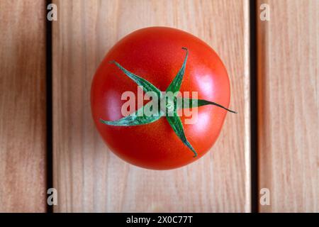 One red tomato on a wooden table, top view Stock Photo