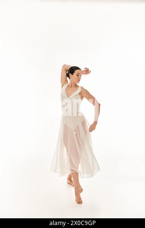 Graceful ballerina in a flowing white dress performs an elegant ...