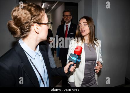 Confident female US politician answers press questions and gives interview for media walking in corridor of government building. American delegation surrounded by crowd of journalists. Press campaign. Stock Photo