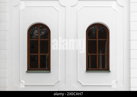 Classical windows with arches and decorative elements in white stone wall. Background photo texture Stock Photo