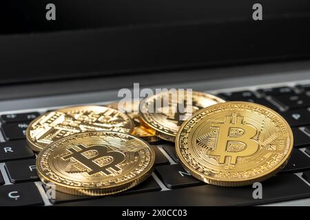 Bitcoin cryptocurrency gold coins on laptop. Stock Photo
