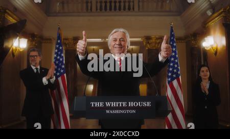 New US President smiles, shows thumbs up during press conference after winning the elections. Senior republican politician poses for cameras for media and television in the White House. Slow motion. Stock Photo