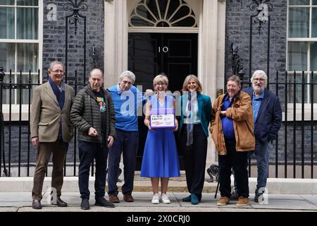 Hosts of The Movers and Shakers podcast (left-right) Sir Nicholas Mostyn, Rory Cellan-Jones, Paul Mayhew-Archer, Gillian Lacey-Solymar Mark Mardell and Jeremy Paxman with Parkinson's UK CEO Caroline Rassell (centre) mark World Parkinson's Day by handing in their 'Parky Charter' petition to 10 Downing Street, London, calling for more support for people with Parkinson's in the UK. Picture date: Thursday April 11, 2024. Stock Photo