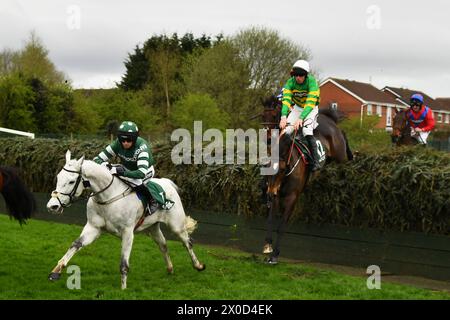 Liverpool, UK, 11th Apr, 2024. Its on the Line (Green and Gold hoops), ridden by Mr Derek O'Connor jumps Bechers Brook, before going on to win the 16.05 Foxhunters' Chase. UK. Photo Credit: Paul Blake/Alamy Sports News Stock Photo