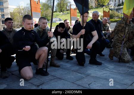 Non Exclusive: KYIV, UKRAINE - APRIL 9, 2024 - People kneel to express their respect during the farewell ceremony of Ukrainian defenders Taras Petrysh Stock Photo