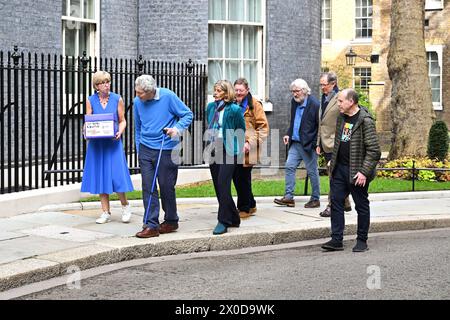 EDITORIAL USE ONLY (left-right) Parkinson's UK CEO Caroline Rassell with Hosts of The Movers and Shakers podcast Paul Mayhew-Archer, Gillian Lacey-Solymar, Mark Mardell, Jeremy Paxman, Sir Nicholas Mostyn and Rory Cellan-Jones mark World Parkinson's Day by handing in their 'Parky Charter' petition to Downing Street, asking for more support for people with the condition. Picture date: Thursday April 11, 2024. Stock Photo