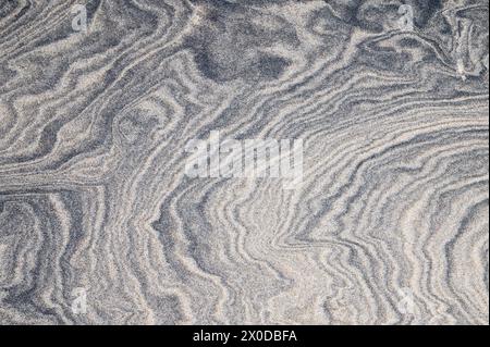 Full frame of dark swirl patterns in the sand Stock Photo