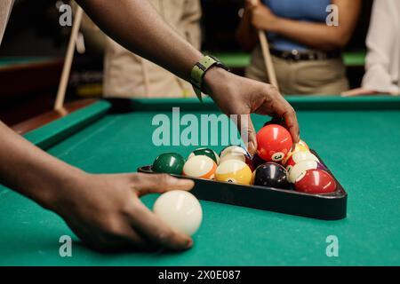 Side view closeup of hands putting billiard balls in triangle frame for pool game copy space Stock Photo