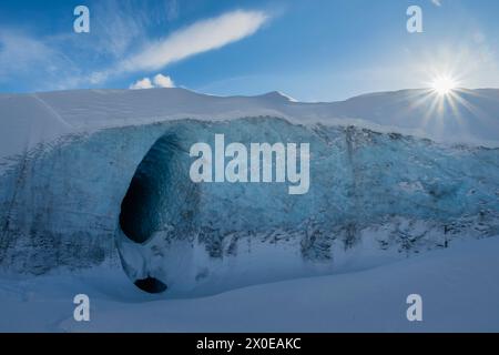 Ice cave on Matanuska Glacier with rising sun in background in Southcentral Alaska. Stock Photo