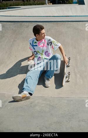 A young man skillfully rides his skateboard up the side of a ramp in a vibrant outdoor skate park on a sunny summer day. Stock Photo