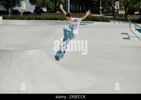 A young man defies gravity as he skillfully rides his skateboard up the ramp in a vibrant outdoor skate park on a summer day. Stock Photo