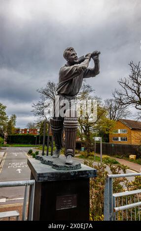 Statue of cricketer, batsman (batter) Eric Bedser, on Bedser Bridge in the town centre of Woking, a town in Surrey, England Stock Photo