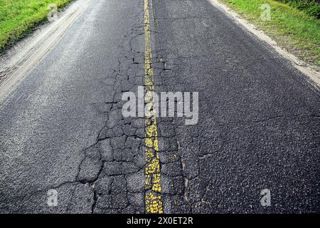 'Road wear: Witnessing the Wear and Tear of Time on the Asphalt's Surface.' Stock Photo