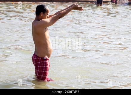 young devotee praying for holy god after bathing in holy river water at morning from flat angle Stock Photo