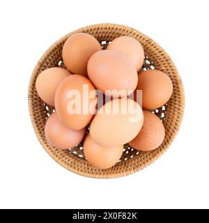 Brown chicken eggs in weave basket isolated on white background, top view, Saved clipping path. Stock Photo