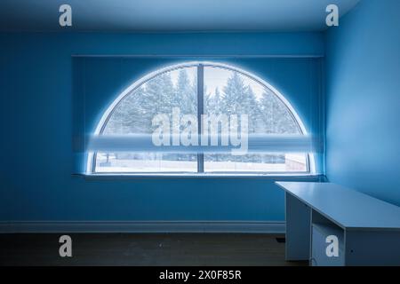 A lunette or half moon window inside a bedroom in a house. Stock Photo