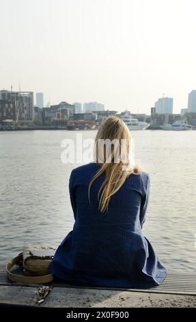 A woman enjoying the view of the Dubai Creek and Old Dubai. Deira, Dubai, UAE. Stock Photo