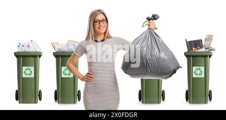 Young woman with a waste bag and recycling bins for different materials isolated on white background Stock Photo