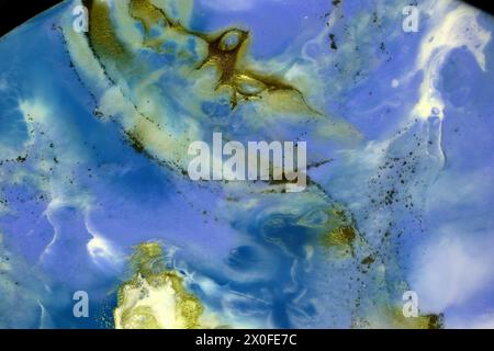 Abstract marble background. Blue color. White and gold chaotic spots. Sometimes black dots. Gold has a green tint. Colors mix together to form differe Stock Photo