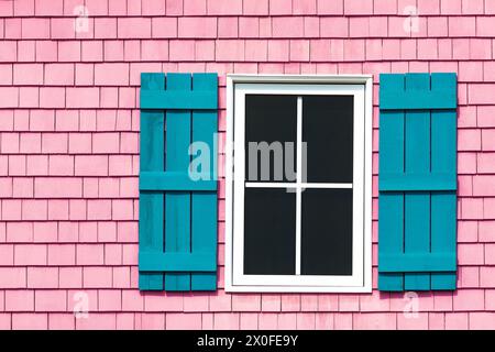 Detail of an old shuttered window on shingle wall. Traditional building exterior in the Magdalen Islands, Canada. Space for text. Stock Photo