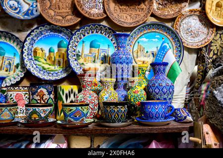 Decorative colorful ceramic plates, cups and pot with traditional uzbekistan ornament on shop in Samarkand in Uzbekistan, Central Asia, Silk Road. Stock Photo