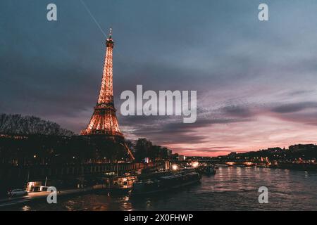 Eiffel Tower at sunset, with the Parisian cityscape in the background and Sena river. Stock Photo