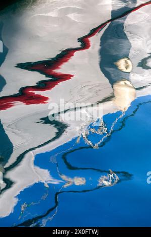 Reversed reflection of a fishing boat in Spetses island, Greece, reflected on the surface of the water at the local port. Stock Photo