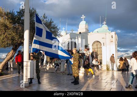 Flag lowering ceremony by Greek soldiers white tourists are watching, atrop Lycabettus hill, in downtown Athens, Greece, Europe. Stock Photo