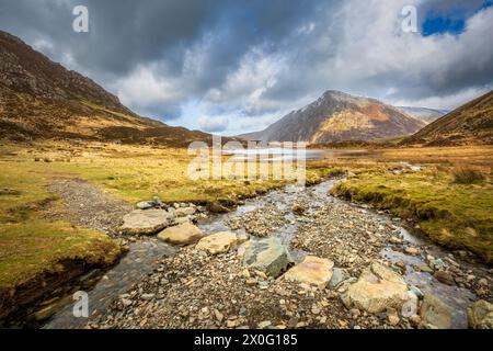 Stepping stones across a mountain stream leading to Llyn Idwal in Cwm Idwal Nature Reserve with Pen yr Ole Wen mountain in the background, Snowdonia, Stock Photo