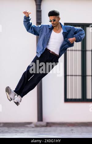 Successful confident handsome young adult jumping outside. Stock Photo