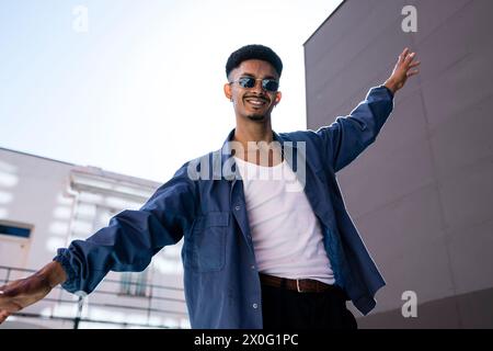 Handsome stylish happy man extended hands and arms outside. Stock Photo