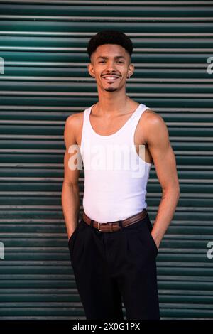 Relaxed carefree young man standing outside looking at camera. Stock Photo