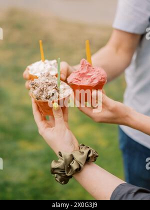 three friends enjoying gelato together outside Stock Photo