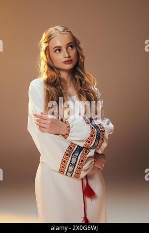 A young mavka, clad in an ornate white dress, embodies the essence of fairy and fantasy in a studio setting. Stock Photo