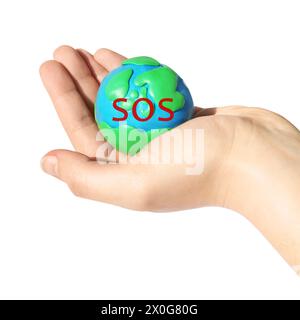 Woman holding plasticine model of planet Earth with word SOS on white background, closeup Stock Photo