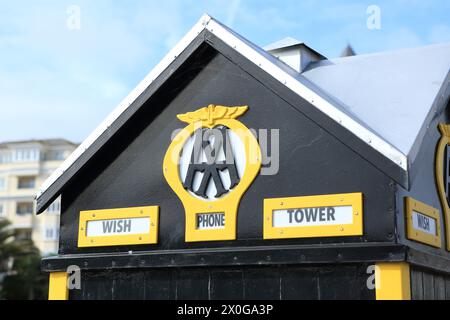 The AA old fashioned phone call box at Wish Tower Eastbourne East Sussex UK yellow paint on black background Stock Photo