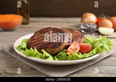 Vegetarian product. Tasty lentil cutlets served on wooden table Stock Photo