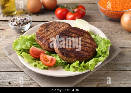 Vegetarian product. Tasty lentil cutlets served on wooden table Stock Photo