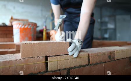 Skilled bricklayer putting red block Stock Photo