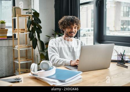 A man of different cultural background sitting at a laptop in a coworking space, focused and engaged in his digital work. Stock Photo