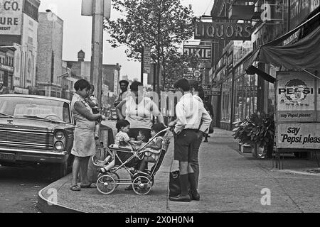 A family with three children in a baby carriage at a street corner in New York's Harlem district. Stock Photo