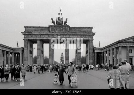People are strolling in front of the Brandenburg Gate at Christmas time 1989 with a Christmas tree on the Straße des 17. [automated translation] Stock Photo
