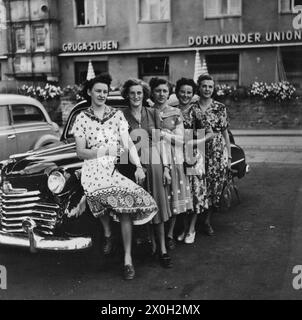 Five young women in summer dresses pose in front of an Opel Olympia in Essen (undated picture). Stock Photo