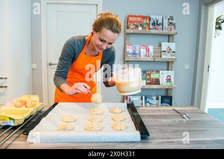 Housewife and Mother Baking Cookies for her Family and Guests. Mid adult caucasian female baking cookies inside her residential, domestic kitchen for ehr family and guests. Kaatsheuvel, Netherlands. MRYES Kaatsheuvel Hoofdstraat Noord-brabant Nederland Copyright: xGuidoxKoppesxPhotox Stock Photo