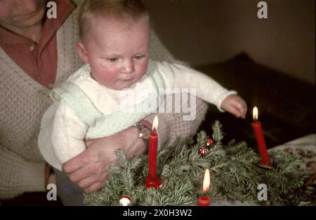 Father with child on his lab in front of an advent wreath with candles. Stock Photo